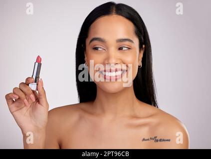 Essayer une nouvelle couleur. une jeune femme attrayante posant avec un rouge à lèvres sur un fond rose Banque D'Images