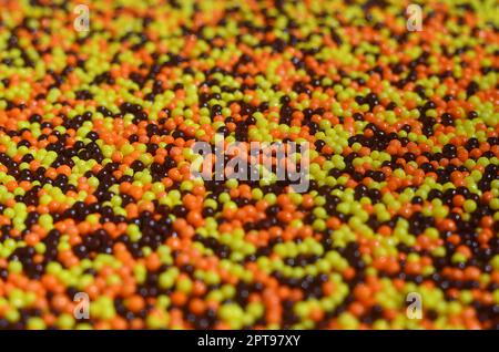 Photo d'arrière-plan d'une variété de vitrage de couleur en poudre sous forme de petites boules. Un nombre énorme de sucré, perles colorées de très petite taille pour décembre Banque D'Images