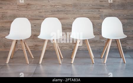 Location de l'entraînement de recrutement du personnel, salle d'attente pour les entrevues et quatre chaises de bureau blanches sur fond de mur de bois vide. Opportunités commerciales dans les entreprises Banque D'Images