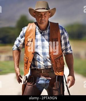 HES le wrangler des bêtes. Un cowboy mature à l'extérieur sur sa ferme Banque D'Images