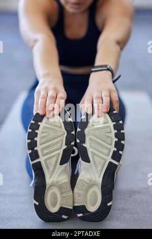 Une femme s'étirant, des chaussures de sport et une athlète touchent les orteils sur un tapis de yoga sur le sol pour la mise en forme des jambes exercice d'échauffement. Athlète féminine, entraînement pour Banque D'Images