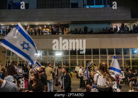 Israël. Des manifestants marchent dans la rue pendant que les gens regardent d'un centre commercial à proximité, lors d'une manifestation en faveur de la réforme judiciaire. La manifestation, l'une des plus importantes de l'histoire du pays, a été organisée à l'appui des réformes judiciaires proposées, qui ont été vivement débattues entre ceux qui les considèrent comme nécessaires pour fixer les pouvoirs excessifs de la Cour, Et ceux qui voient ces réformes comme un danger pour la démocratie israélienne. Banque D'Images