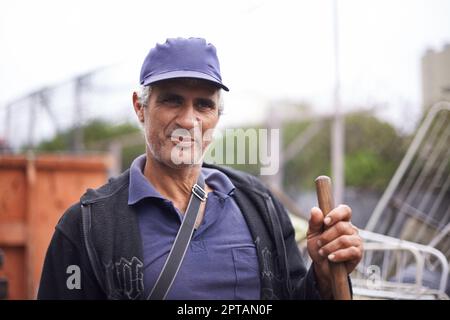 Le travail est difficile à réaliser. Un portrait court d'un balai de rue debout avec son balai Banque D'Images