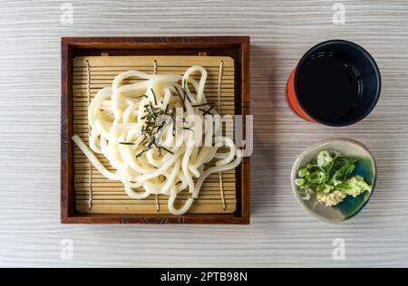 Zaru Udon froid, nouilles aux algues grillées coupées servies dans un panier de bambou avec une sauce mentsuyu rafraîchissante, wasabi, gingembre et groupage Banque D'Images