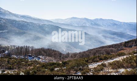 Brouillard ambiant entre les sommets enneigés de la Sierra de Gredos. La Garganta, Vallée de l'Ambroz, Estrémadure, Caceres, Espagne Banque D'Images