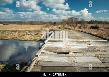 Planche cassée dans un pont en bois sur la rivière, jour ensoleillé, Czulczyce, Pologne Banque D'Images