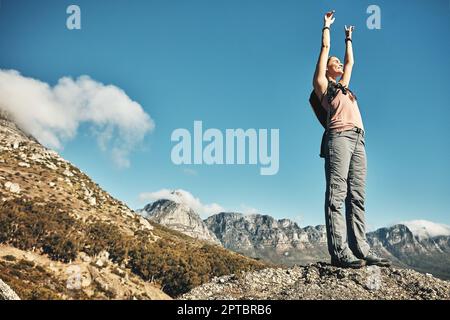 La randonnée pédestre est un moyen de découvrir la liberté. une jeune femme qui fête pendant une randonnée dans les montagnes. Banque D'Images