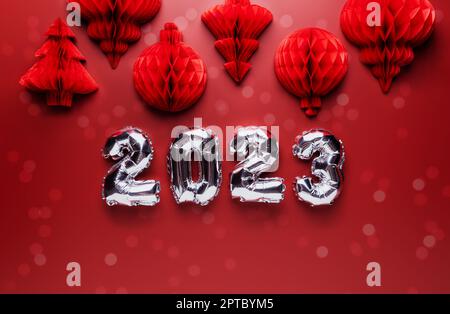 Arrière-plan de Noël ou du nouvel an. Couleur rouge bordeaux avec décorations et numéros de 2023 bordeaux brillants argentés. Copier la zone d'espace pour la publicité. Banque D'Images