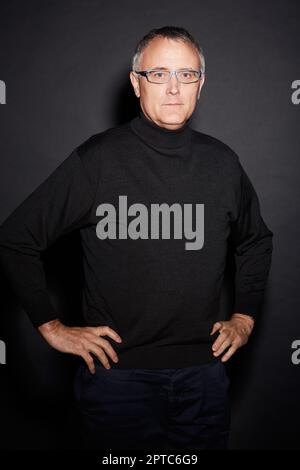 HES naturellement confiant. Studio portrait d'un homme mature isolé sur noir Banque D'Images