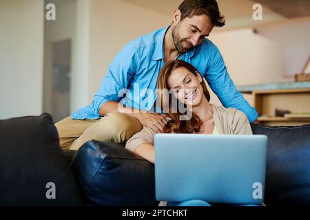 Se connecter de plusieurs façons. un jeune couple affectueux se détendant sur le canapé à la maison Banque D'Images