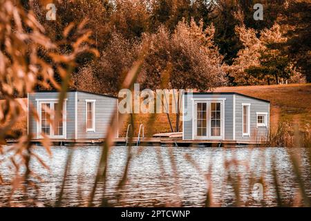 Couple de cabines flottantes grises sur le lac. Vivre sur une maison flottante est très attrayant. Banque D'Images