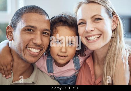 Heureux, sourire et parents interraciaux avec leur enfant assis, liant et relaxant ensemble. Portrait d'une mère, d'un père et d'une jeune fille avec bonheur Banque D'Images