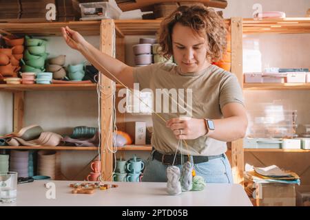 Femme en bois naturel sûr sur le bureau, style écologique. Perles de cerclées. Jouet de dentition avec décoration de ferraillement de cercueil. Travail de fabrication à la main de à Banque D'Images