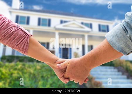 Couple tenant les mains approchant de la porte avant de la nouvelle maison. Banque D'Images