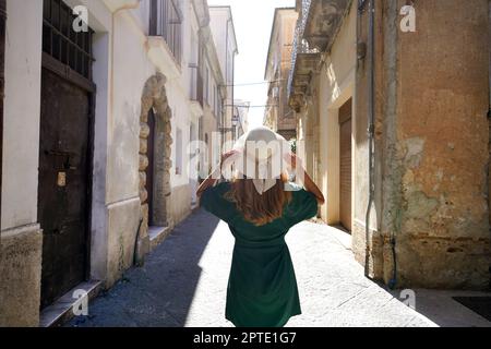 Vacances en Calabre, Italie. Vue arrière de la belle fille touristique élégante marchant entre les ruelles étroites de Pizzo Calabro ville historique de Ital sud Banque D'Images