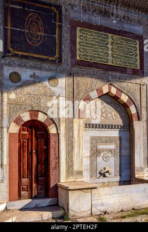 Façade de l'ancienne mosquée ensoleillée avec ses fresques colorées et ses reliefs dans la ville d'Istanbul en Turquie Banque D'Images