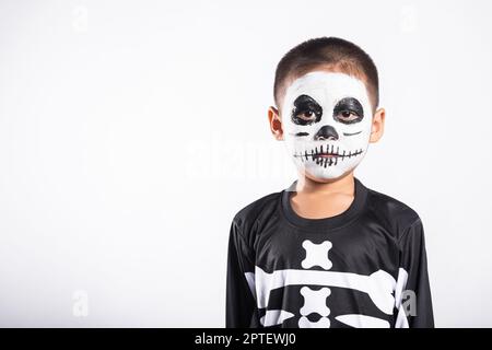 Halloween enfant. Portrait de petit garçon asiatique portant le squelette costume studio tourné isolé fond blanc, Child man horreur visage peinture maquillage Banque D'Images