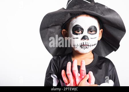 Halloween enfant. Portrait de petit garçon asiatique portant le squelette costume studio tourné isolé fond blanc, Child man horreur visage peinture maquillage Banque D'Images