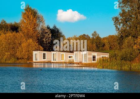 Magnifique paysage d'automne avec cabines flottantes grises sur le lac et arbres automnaux. Vivre sur une maison flottante est très attrayant. Banque D'Images