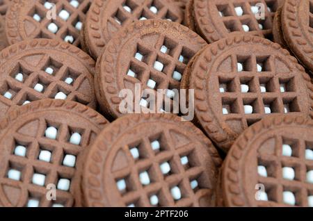 Image détaillée des biscuits ronds marron foncé avec remplissage de noix de coco. Image de fond de plusieurs gâteries pour le thé Banque D'Images