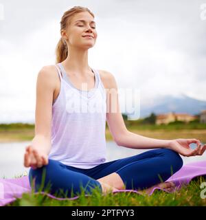 Quand vous êtes propriétaire de votre souffle, personne ne peut voler votre paix. une jeune femme faisant du yoga à l'extérieur Banque D'Images