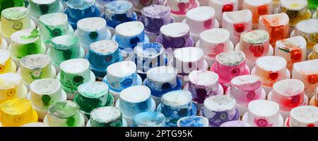 Un motif dans un bon nombre de buses d'un pulvérisateur de peinture pour dessiner des graffitis, des traînées en différentes couleurs. Les capuchons en plastique sont disposés en plusieurs rangées pour Banque D'Images