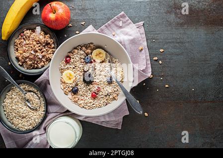 Un bol de granola et de muesli secs servi avec des fruits frais. Plaque à flocons d'avoine. Alimentation saine, alimentation. Vue de dessus. Banque D'Images