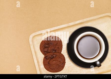 Plat de bonbons faits maison, biscuits au chocolat et café chaud sur plateau en bois sur fond de bois. Banque D'Images