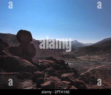 sommet de montagne avec des plaines en arrière-plan, deux rochers empilés sur une montagne en pierre, un chemin routier au loin, paysage montagneux d'été wi Banque D'Images