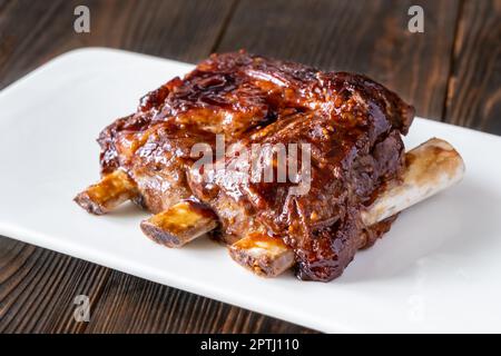 Côtelettes de porc au barbecue sur la plaque blanche Banque D'Images