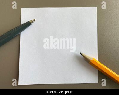 Petits morceaux carrés de papier pour notes et notes sur le bureau et stylos à bille avec crayons. Travail d'entreprise. Banque D'Images