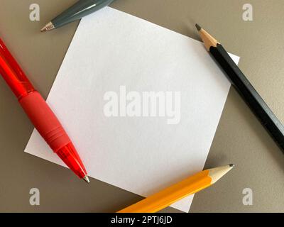 Petits morceaux carrés de papier pour notes et notes sur le bureau et stylos à bille avec crayons. Travail d'entreprise. Banque D'Images