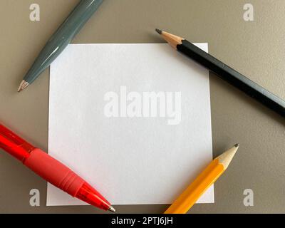 Petits morceaux carrés de papier pour notes et notes sur le bureau et stylos à bille avec crayons. Travail d'entreprise. Banque D'Images
