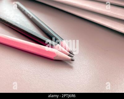 Trois crayons sont nettement aiguisés à côté des chemises avec des feuilles de papier et des documents sur le bureau de travail dans le bureau. Papeterie. Banque D'Images