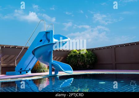 piscine avec toboggans sur fond bleu ciel. concept été Banque D'Images