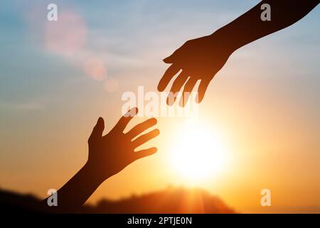 Silhouette d'aider les mains et de développer une amitié. concept de la journée internationale de la paix. aidez un ami Banque D'Images