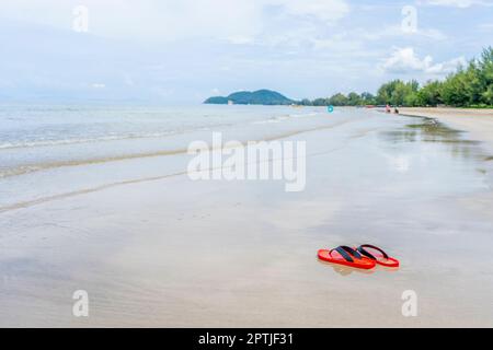 Chaussures rouges sur la plage à la lumière du jour Banque D'Images