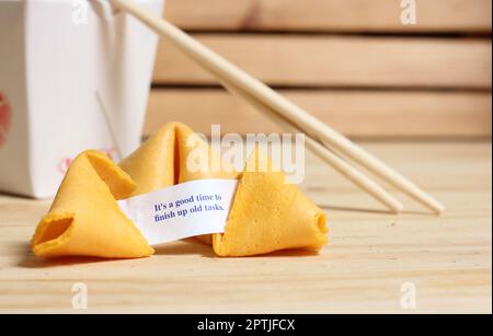 Fortune cookie avec phrase c'est le bon moment pour terminer de vieilles tâches. Retirer le récipient à l'arrière Banque D'Images