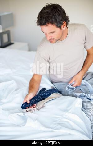 Choix de la cravate. Homme essayant de déterminer quelle cravate va bien avec sa chemise Banque D'Images