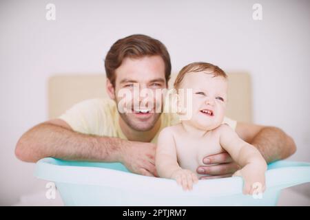 HES toujours là pour s'occuper d'elle. Un jeune père se liant à sa fille au moment du bain Banque D'Images