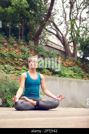 Zone sans stress. une jeune femme pratiquant le yoga à l'extérieur Banque D'Images