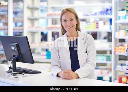 Chaque client est un individu. Portrait d'un pharmacien attrayant debout au comptoir d'ordonnance Banque D'Images