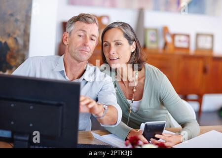 Trier leurs finances ensemble. un couple marié mature qui passe par ses finances à la maison Banque D'Images