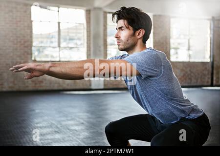 Travailler son corps de la tête aux pieds. un jeune homme s'entraîner dans la salle de gym. Banque D'Images