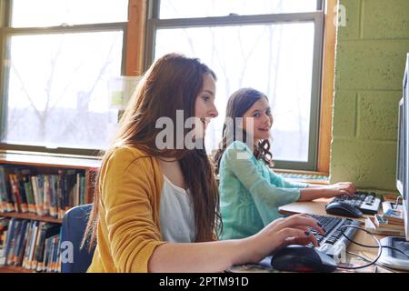 Les enfants plus tôt commencent à utiliser l'ordinateur, le mieux. enfants élémentaires travaillant sur des ordinateurs à l'école. Banque D'Images