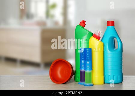 Différentes fournitures de nettoyage de toilettes sur une table en bois dans la salle de bains, espace pour le texte Banque D'Images