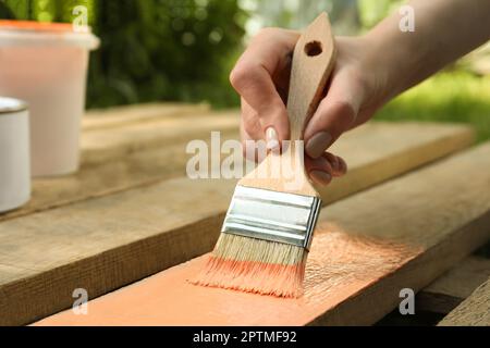 Femme peinture de surface en bois avec teinture de corail à l'extérieur, gros plan Banque D'Images