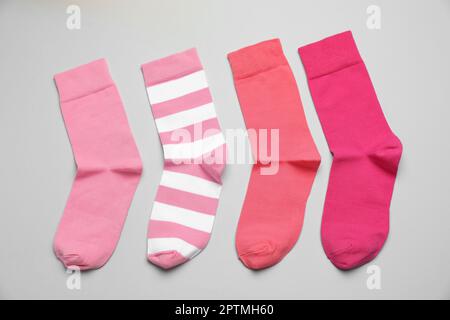 Différentes chaussettes roses sur fond clair, à plat Banque D'Images
