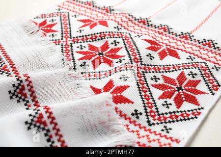 Rushnyk avec broderie traditionnelle ukrainienne sur table blanche, gros plan. Artisanat national Banque D'Images