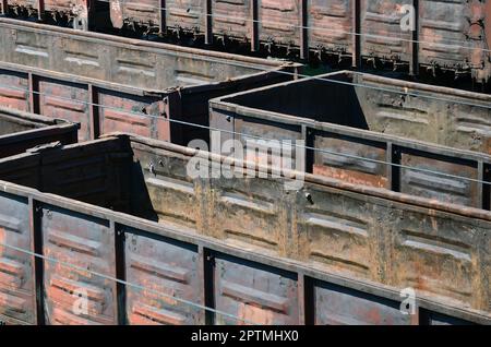 Vieux wagons rouillés vide sur des rails en journée d'été. La lumière du soleil dans les wagons sales sous l'air libre Banque D'Images